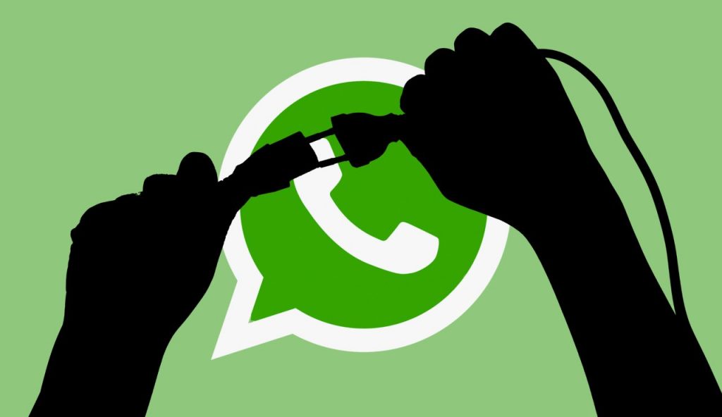 Una persona stacca una spina davanti all'icona di WhatsApp per indicare che non sarà più disponibile su alcuni dispositivi