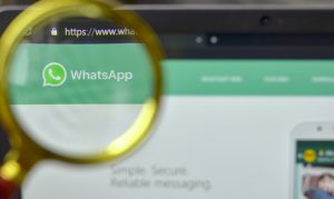 Una lente di ingrandimento davanti alla pagina web di WhatsApp