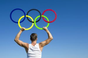 Uomo regge lo stemma delle olimpiadi: i cinque cerchi interconnessi