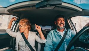 Coppia felice alla guida di un'auto